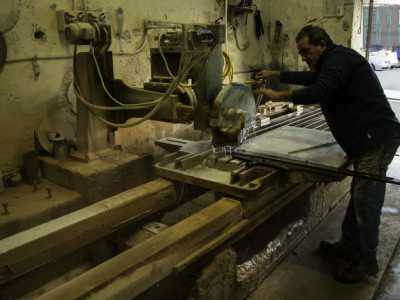Un marmista costruttore di lapidi taglia una lastra di marmo